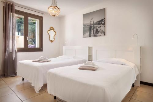 2 Betten in einem Zimmer mit weißer Bettwäsche in der Unterkunft Casa Al Lago With Pool in Torri del Benaco