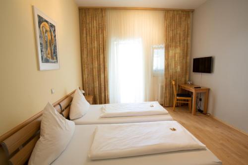 スパイヤーにあるSpiranova Restaurant und Hotelのベッド2台とテレビが備わるホテルルームです。