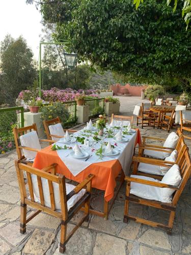 a wooden table with chairs and a table set for a meal at Auberge des Cascades Imouzzer - Paradise Valley in Imouzzer des Ida Ou Tanane