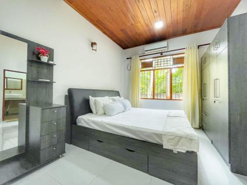 a bedroom with a large bed and a window at Ceylon Serenity Villa in Beruwala