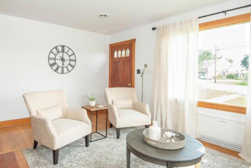 sala de estar con 2 sillas, mesa y ventana en Pine Grove Cottage, en Chambersburg
