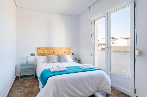 a white bedroom with a large bed and a window at Casa Las Rosas in Iniesta