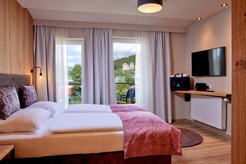 Una cama o camas en una habitación de HOTEL SONNBLICK Kaprun, Salzburg - including Summer Card