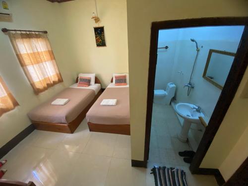 a small bathroom with two beds and a sink at A Tee Guesthouse in Luang Prabang