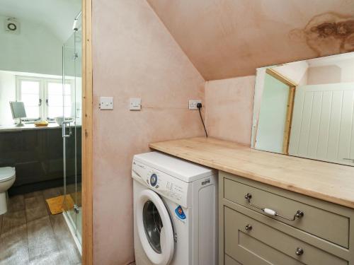 a bathroom with a washing machine and a sink at The Bake House in Bridgend