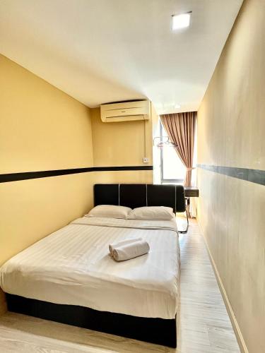 a bedroom with a bed with a towel on it at Cozy Living Sky Apartment in Kota Kinabalu