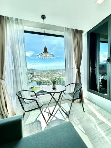 a living room with a table and chairs and a large window at Cozy Living Sky Apartment in Kota Kinabalu