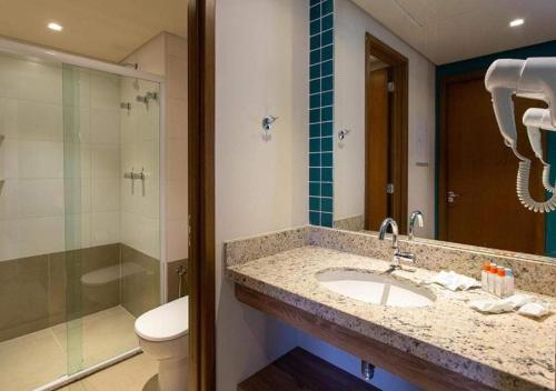 uma casa de banho com um lavatório, um chuveiro e um WC. em Enjoy Solar das Águas Olimpia em Olímpia