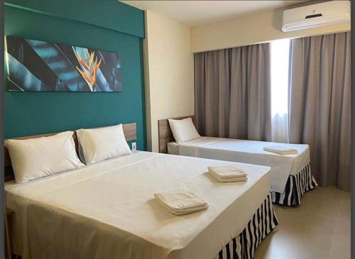 um quarto de hotel com duas camas e uma parede azul em Enjoy Solar das Águas Olimpia em Olímpia