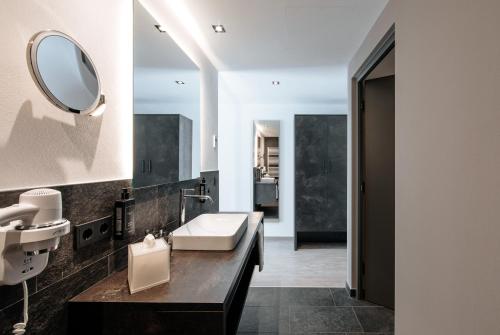 W łazience znajduje się umywalka i lustro. w obiekcie La Vista Nature Living w mieście Tirolo