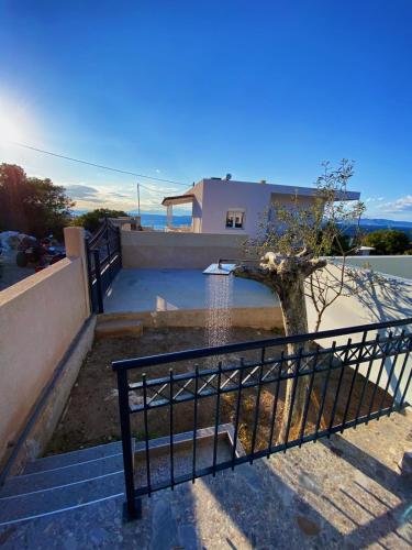 a house with a gate and stairs with a tree at The Dona House in Vaia