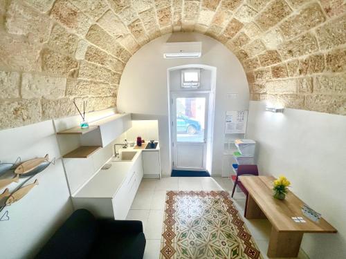 een kleine kamer met een stenen muur en een tafel bij B&B Suite Amare Polignano in Polignano a Mare