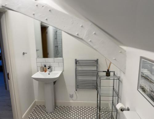 a bathroom with a sink and a mirror at Beautiful, spacious 3 bed Brixham apartment in Brixham