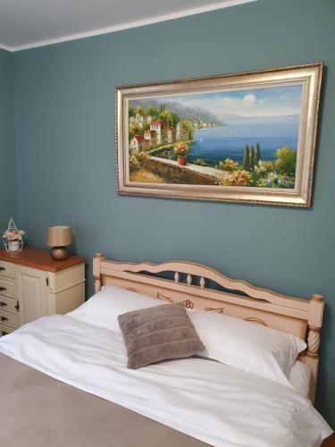 a bedroom with a bed with a painting on the wall at Vila Sunset 2 in Galaţi
