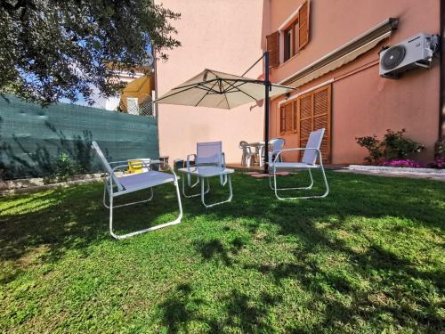 a table and chairs and an umbrella in a yard at N172 - Numana, meraviglioso trilocale con giardino in Sirolo