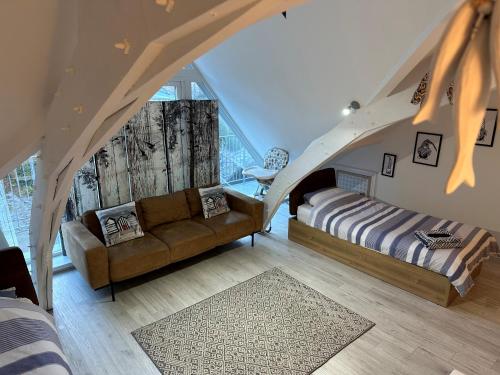 a attic room with a couch and a bed at Beautiful, spacious 3 bed Brixham apartment in Brixham