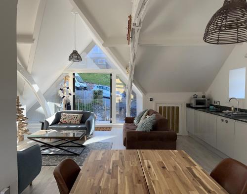 a kitchen and living room with a table and chairs at Beautiful, spacious 3 bed Brixham apartment in Brixham