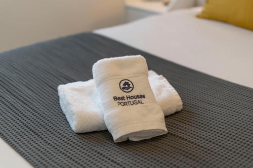 biały ręcznik siedzący na łóżku w pokoju w obiekcie Best Houses 74 - SurfSide Lodge w mieście Peniche