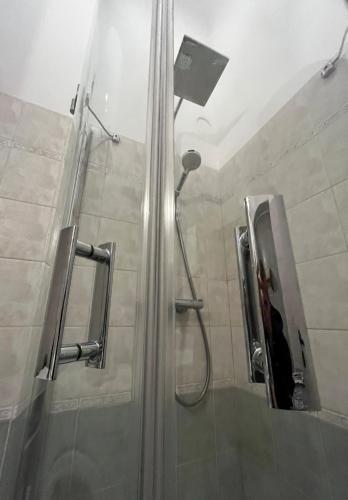 a shower with a glass door and a shower at ApartmentVillaSolomon7 - Dunakanyar Apartman Visegrád Panorámás in Visegrád