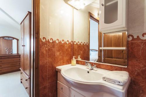 een badkamer met een wastafel en een spiegel bij Best Houses 45 - Beautiful ocean and city view in Peniche