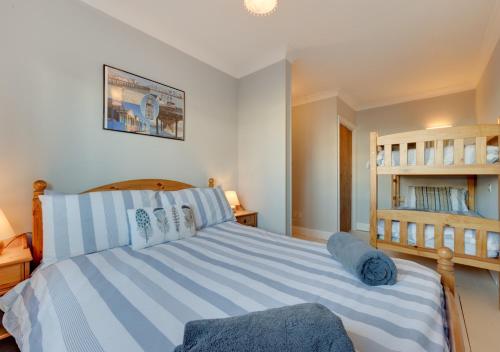 a bedroom with a large bed with blue and white stripes at Hightide in Southwold