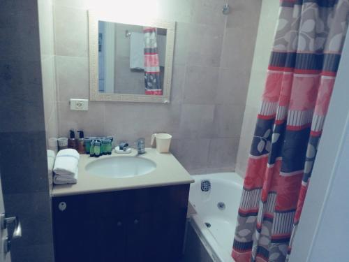 a bathroom with a sink and a shower curtain at דירות נופש מרינה הרצליה in Herzliyya B