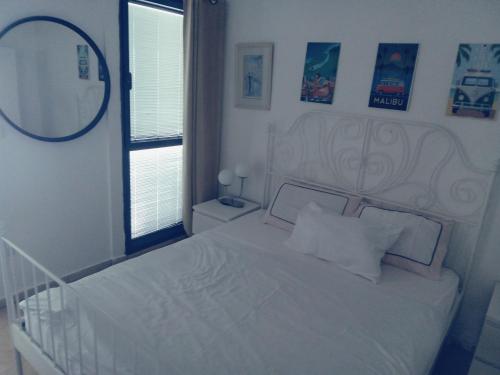 Habitación blanca con cama y espejo en דירות נופש מרינה הרצליה en Herzliyya B