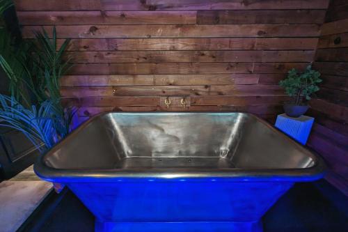 a blue tub in a room with a wooden wall at The Bells - Luxury Serviced Apartments in Leeds