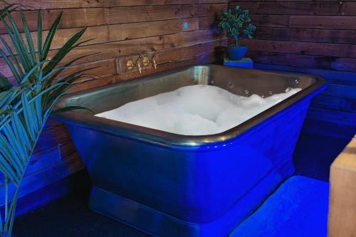 a blue bath tub sitting next to a plant at The Bells - Luxury Serviced Apartments in Leeds