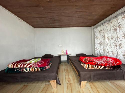 a room with two beds and a table in it at Rock View Rishop in Rishop