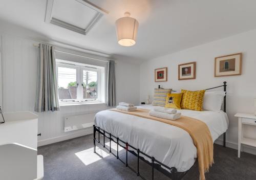a bedroom with a large bed and a window at Japonica Cottage in Wenhaston