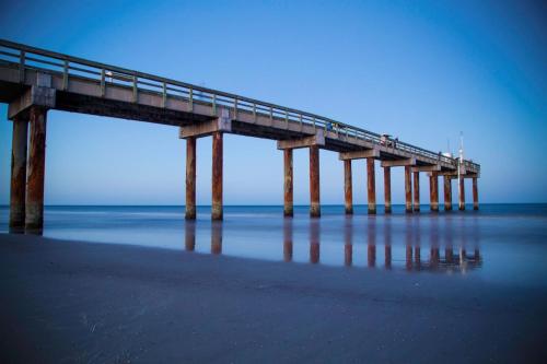 a pier in the ocean with people walking on it at Unit 2105 - Ocean & Racquet Resort in Saint Augustine Beach