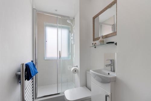 a white bathroom with a shower and a sink at Exeter City Centre Apartments Stoop Apartment in Exeter