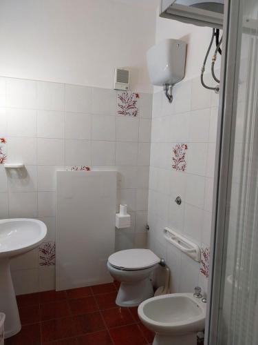 Baño blanco con aseo y lavamanos en Al Casalino House en Ronciglione