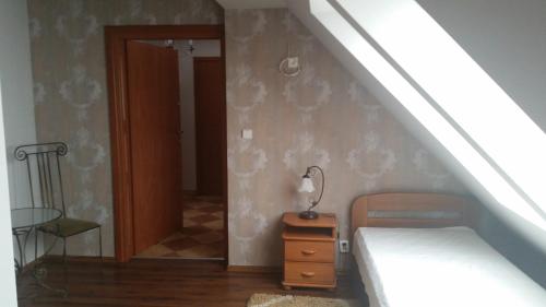 a room with a bed and a table with a lamp at Villa Lena in Gdańsk
