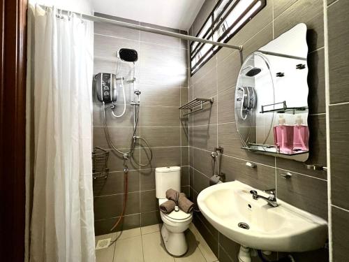 a bathroom with a shower and a sink and a toilet at Desaru Utama Villa by Antlerzone in Bandar Penawar