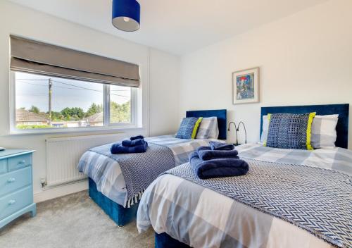 a bedroom with two beds and a window at Loxwood in Reydon