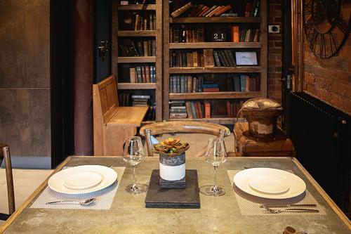 a table with plates and wine glasses on it at The Bells - Luxury Serviced Apartments in Leeds