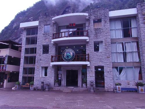 a large stone building with a clock on it at Hostal Pablo's House in Machu Picchu