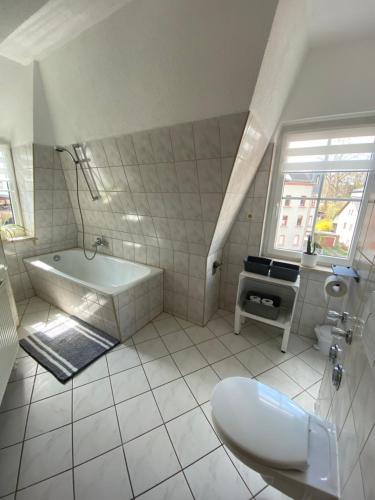 Baño blanco con bañera y lavamanos en Geräumiges Stadtapartment, en Lichtenstein
