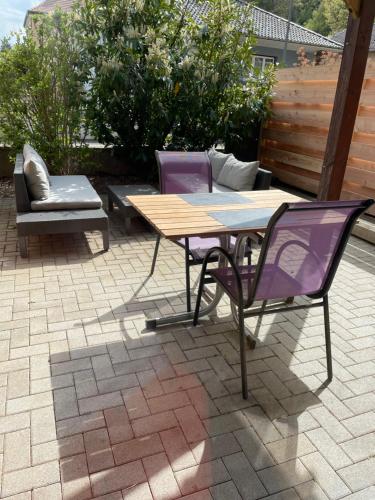 eine Terrasse mit 2 Stühlen, einem Tisch und einer Bank in der Unterkunft L‘atelier in Châtenois