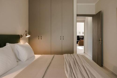 um quarto com uma grande cama branca e um closet em Rosairbe Villa Kefalonia em Cefalônia