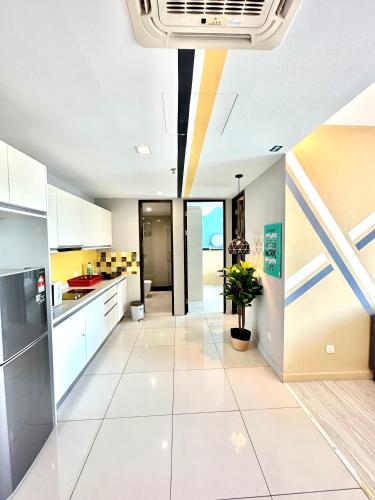 a kitchen with white cabinets and a potted plant at Cozy Living Sky Apartment in Kota Kinabalu