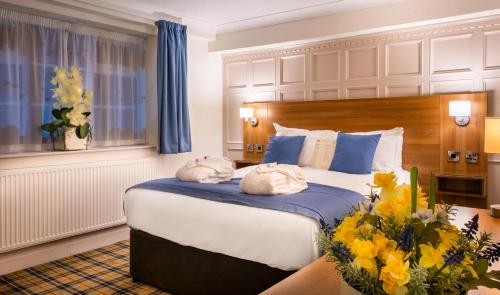 sypialnia z dużym łóżkiem z ręcznikami w obiekcie Last Drop Village Hotel & Spa w mieście Bolton