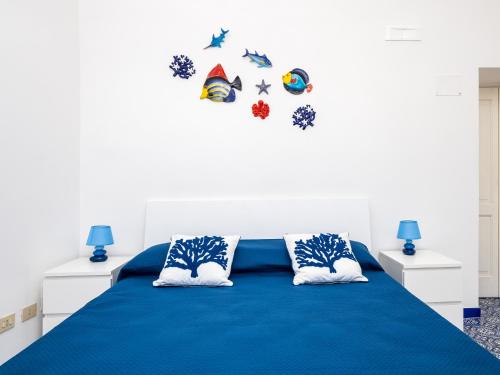 a bedroom with a blue bed with two pillows at Positano Dream Home in Positano