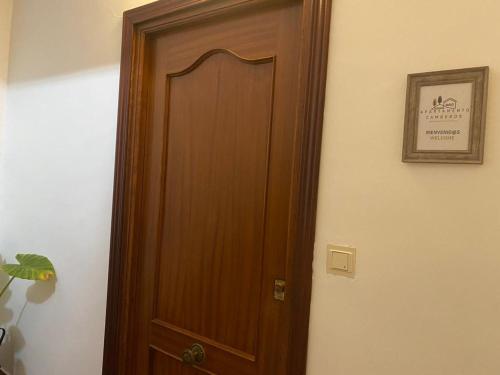 a wooden door in a room with a picture on the wall at Apartamento Camberos Antequera in Antequera