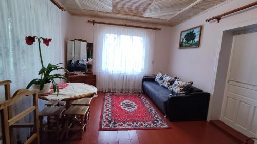 a living room with a couch and a table at Bat'kivska Hata in Stari Kuty
