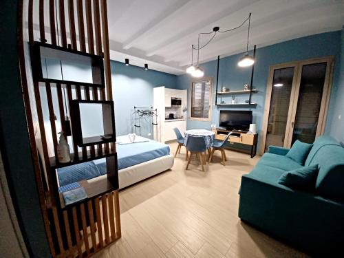 a bedroom with a bed and a couch and a table at Ca Sà Bellò San Vito Lo Capo in San Vito lo Capo