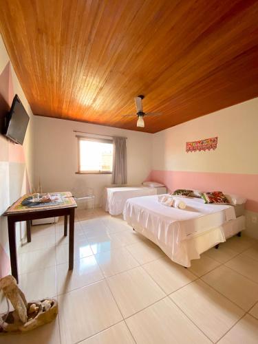 a bedroom with two beds and a wooden ceiling at Topo do Cipó Ecopousada Vegana in Serra do Cipo