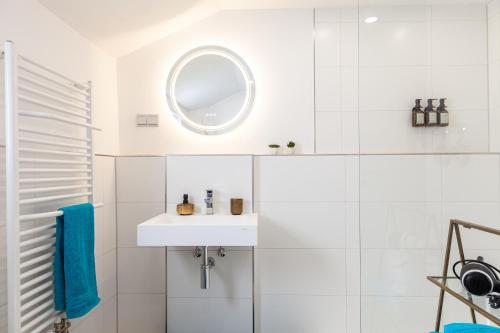 a white bathroom with a sink and a mirror at nidusROOMS: Art Déco Apartment nähe Heidelberg in Leimen